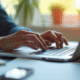 Mains tapant sur un clavier d'ordinateur avec documents et smartphone